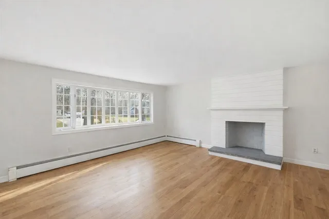 wooden floor fireplace and windows in an empty room