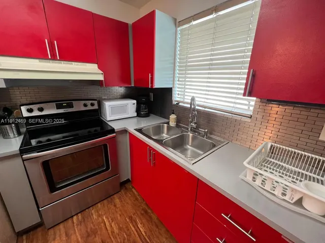 a kitchen with stainless steel appliances a stove a sink and cabinets