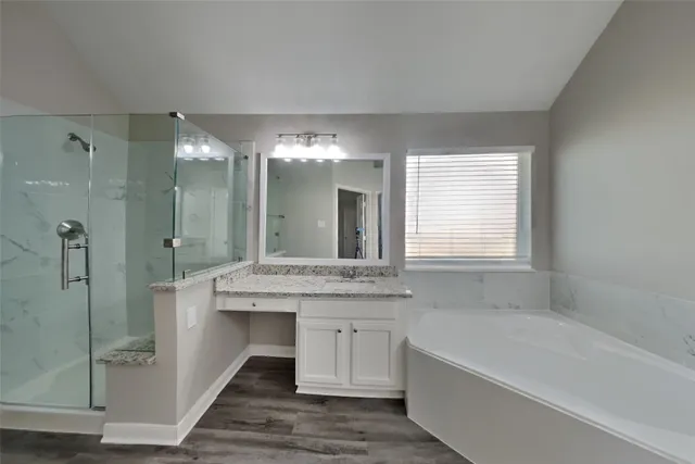 a bathroom with a granite countertop sink a mirror and a bathtub