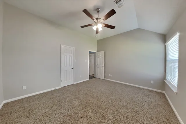 an empty room with windows and fan