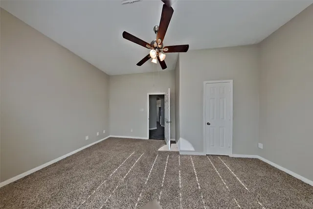 a view of a room with a ceiling fan and hardwood floor