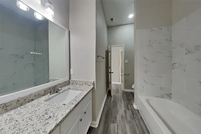 a spacious bathroom with a granite countertop tub sink and mirror