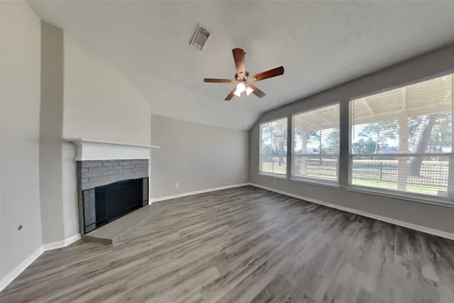 a view of an empty room with a fireplace and a window