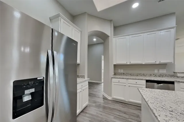 a kitchen with stainless steel appliances granite countertop a refrigerator and a stove