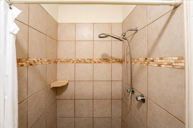 a bathroom with a sink a toilet a mirror and shower