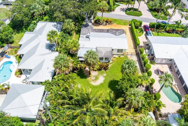 an aerial view of a city with lots of residential buildings ocean and mountain view in back
