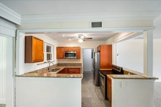 a kitchen with stainless steel appliances granite countertop sink and refrigerator
