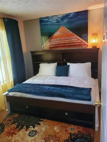 a bed sitting in a bedroom next to a window