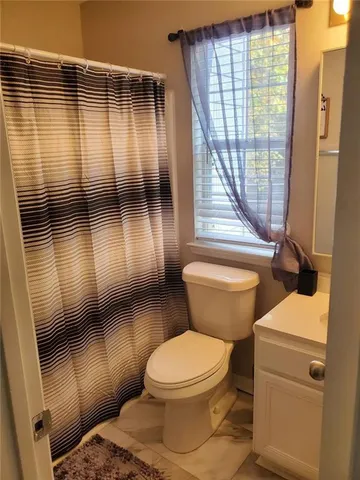 a bathroom with a toilet and a shower