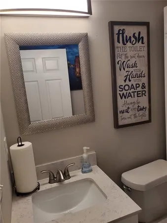 a bathroom with a toilet sink and mirror
