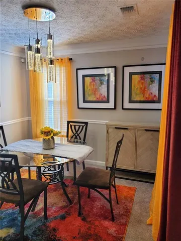 a view of a dining room with furniture and chandelier