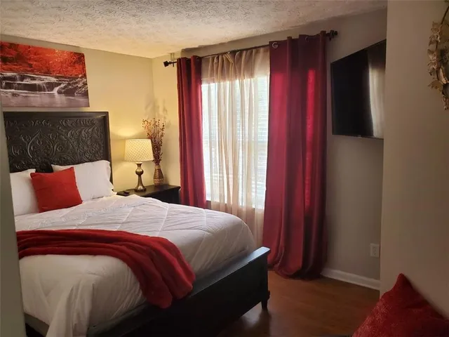 a bedroom with a bed and wooden floor