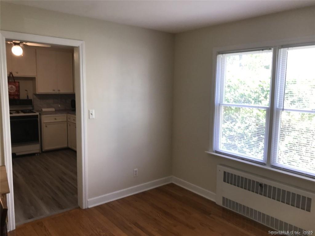 722 Knapps Highway, Unit 722 Fairfield, CT 06825 - Photo 4 of 7 wooden floor in an empty room with a window