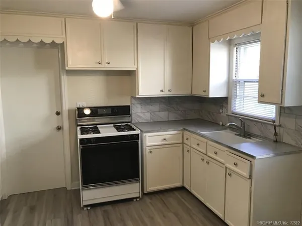 a kitchen with cabinets appliances and a window