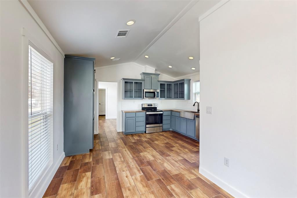6715 Timberhaven Court Granbury, TX 76049 - Photo 13 of 40 a open kitchen with kitchen island a sink stove and a refrigerator