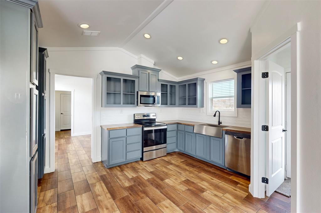 6715 Timberhaven Court Granbury, TX 76049 - Photo 14 of 40 a kitchen with stainless steel appliances granite countertop a refrigerator and a stove top oven
