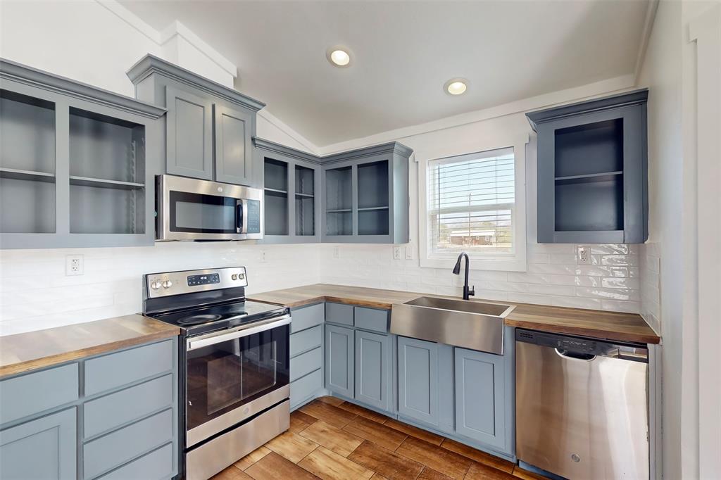 6715 Timberhaven Court Granbury, TX 76049 - Photo 15 of 40 a kitchen with stainless steel appliances a stove sink microwave and cabinets