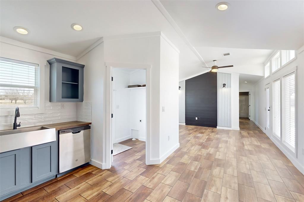 6715 Timberhaven Court Granbury, TX 76049 - Photo 25 of 40 a view of a kitchen with a sink and dishwasher with wooden floor