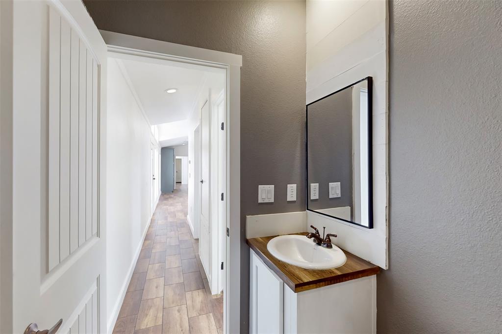 6715 Timberhaven Court Granbury, TX 76049 - Photo 33 of 40 a bathroom with a sink and a mirror