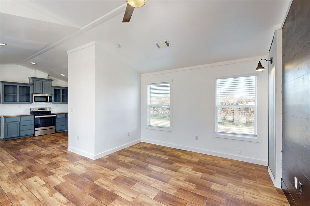 6715 Timberhaven Court Granbury, TX 76049 - Photo 10 of 40 a view of an empty room with kitchen and a window