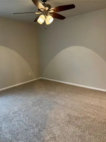 an empty room with a chandelier fan