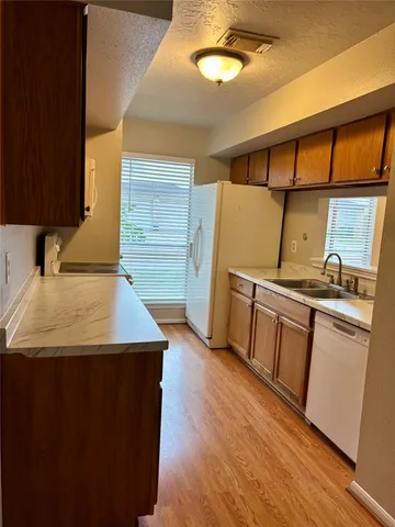 a kitchen with stainless steel appliances granite countertop a sink and wooden cabinets