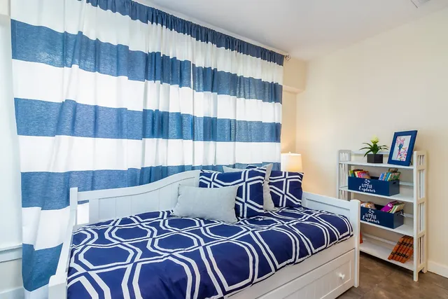 a view of a bedroom with a bed and a window