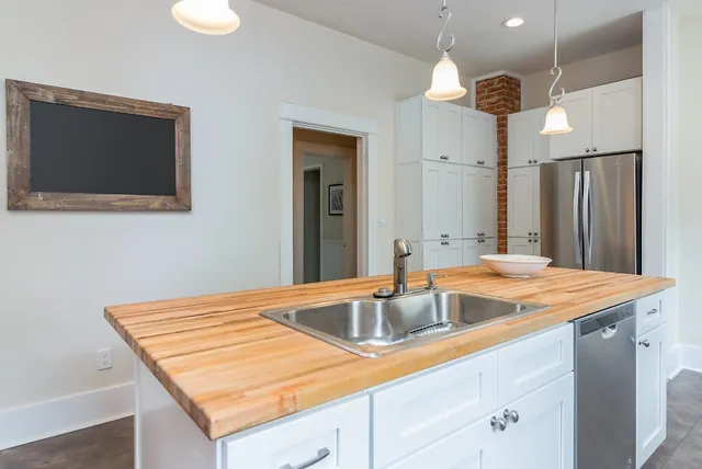 a room with kitchen island a sink and chandelier
