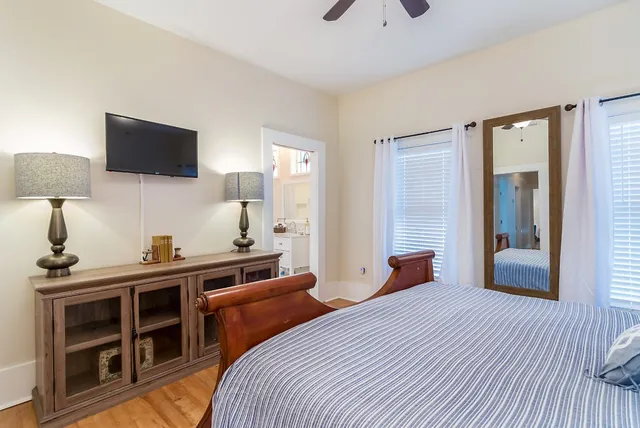 a bedroom with a bed and a flat tv screen on dresser