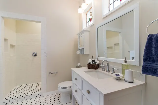 a bathroom with a sink a toilet and shower