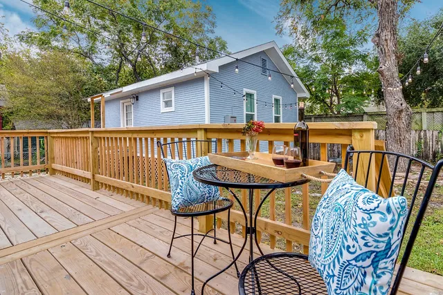 a view of a house with wooden deck and furniture