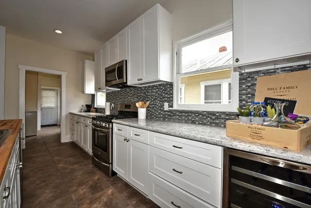 a kitchen with granite countertop a sink stainless steel appliances and cabinets