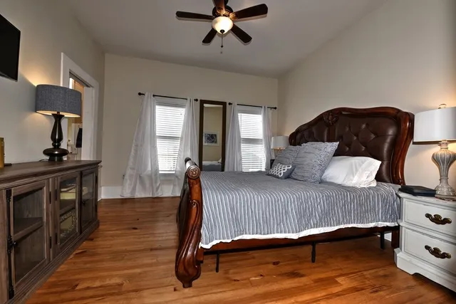 a bedroom with a bed and wooden floor