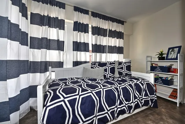 a bedroom with a bed and a black white checkered floor