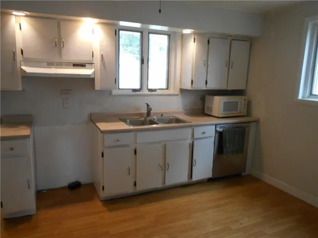 a kitchen with a sink stove and cabinets