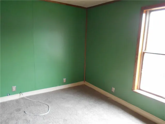 an empty room with a window and a ceiling fan