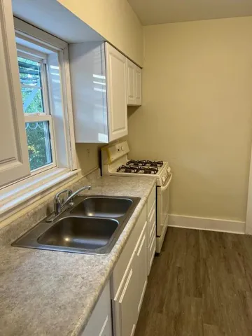 a kitchen with a sink a stove and a window