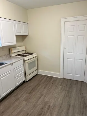 a kitchen with cabinets and wooden floor