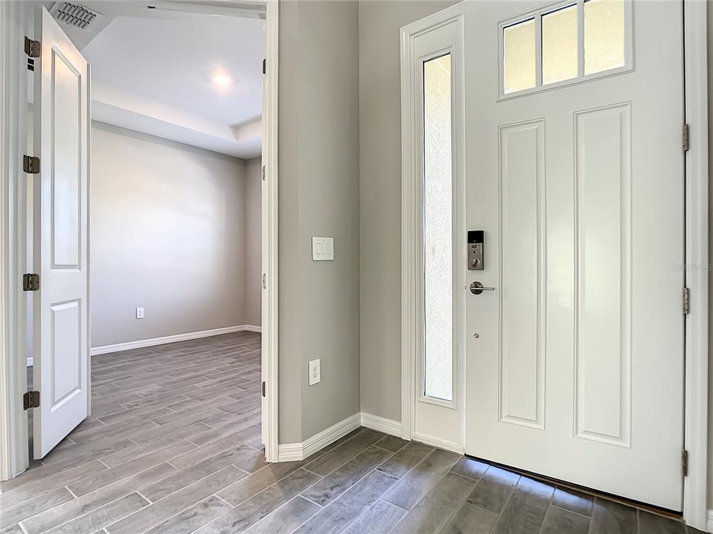 2675 Ridgetop Lane Clermont, FL 34711 - Photo 15 of 56 an empty room with wooden floor and windows