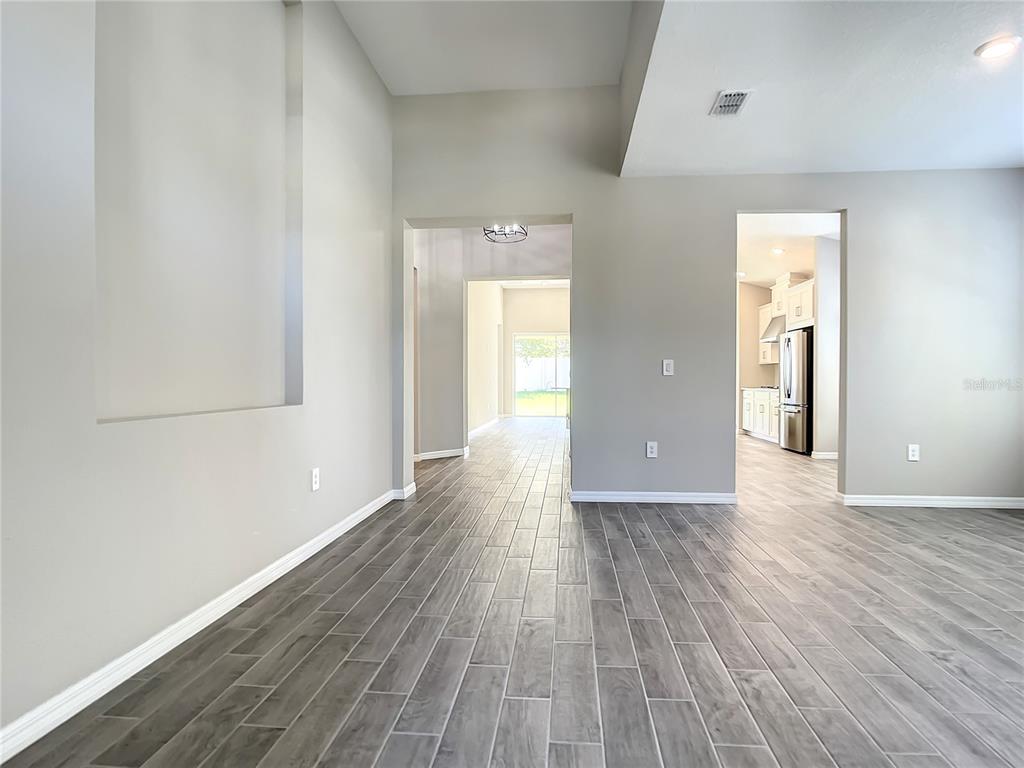 2675 Ridgetop Lane Clermont, FL 34711 - Photo 17 of 56 a view of an empty room with wooden floor and a window