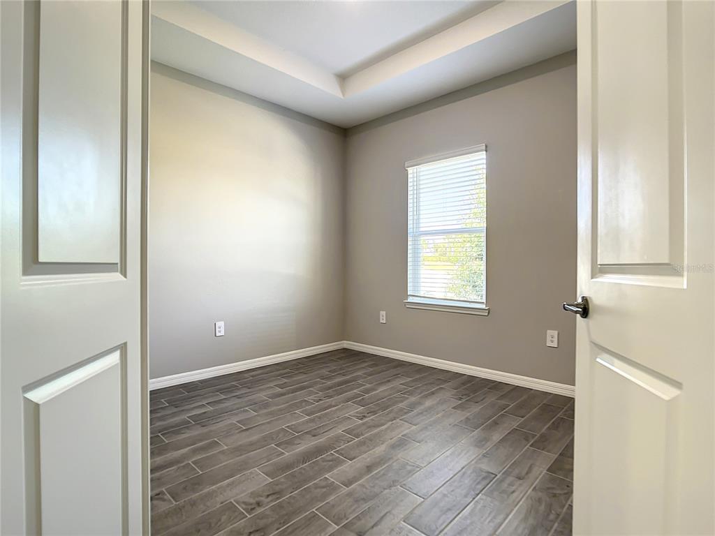 2675 Ridgetop Lane Clermont, FL 34711 - Photo 18 of 56 a view of an empty room with wooden floor and a window