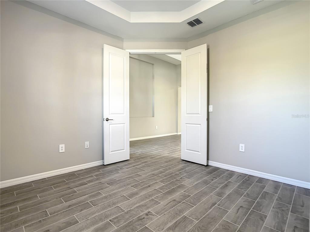 2675 Ridgetop Lane Clermont, FL 34711 - Photo 20 of 56 an empty room with wooden floor and windows