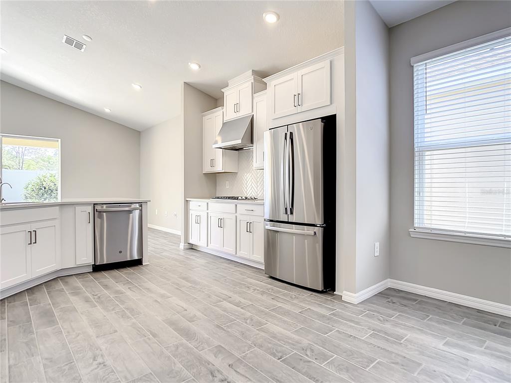 2675 Ridgetop Lane Clermont, FL 34711 - Photo 27 of 56 a kitchen with stainless steel appliances a refrigerator sink and cabinets