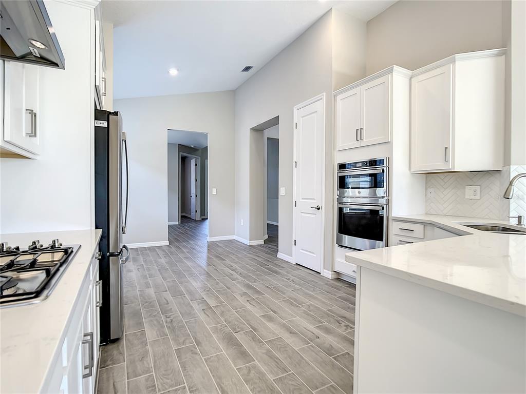 2675 Ridgetop Lane Clermont, FL 34711 - Photo 32 of 56 a kitchen with stainless steel appliances a stove a sink and white cabinets