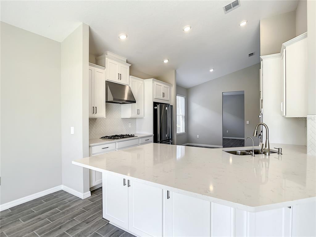 2675 Ridgetop Lane Clermont, FL 34711 - Photo 33 of 56 a large kitchen with stainless steel appliances granite countertop a sink and a stove