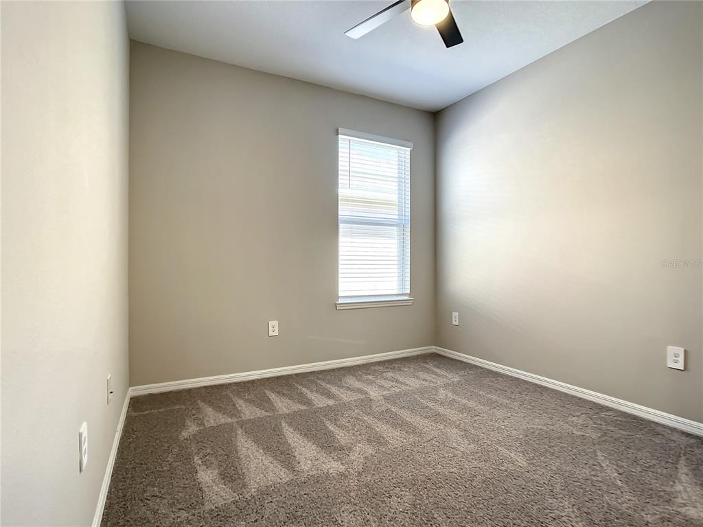 2675 Ridgetop Lane Clermont, FL 34711 - Photo 42 of 56 an empty room with window and chandelier fan