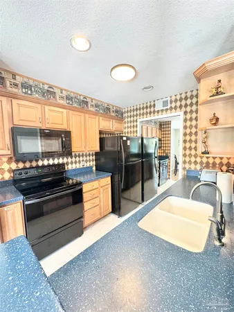 a large kitchen with stainless steel appliances and large windows