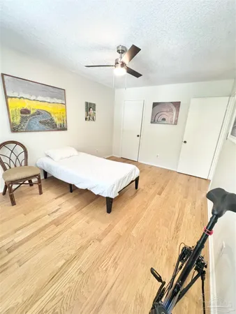 a bedroom with a bed and wooden floor