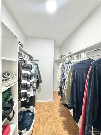 a view of walk in closet with clothes and shoes