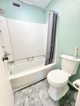 a white toilet sitting next to a bath tub